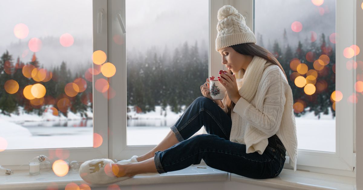 Téli ablakban ülő nő, elmélyült, befelé figyelő állapotban